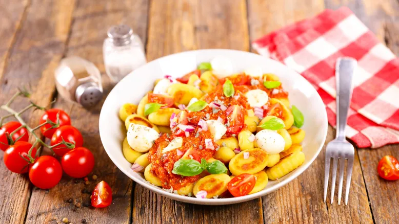 Assiette de gnocchis à la sauce tomate, billes de mozzarella et basilic, tomates cerises.