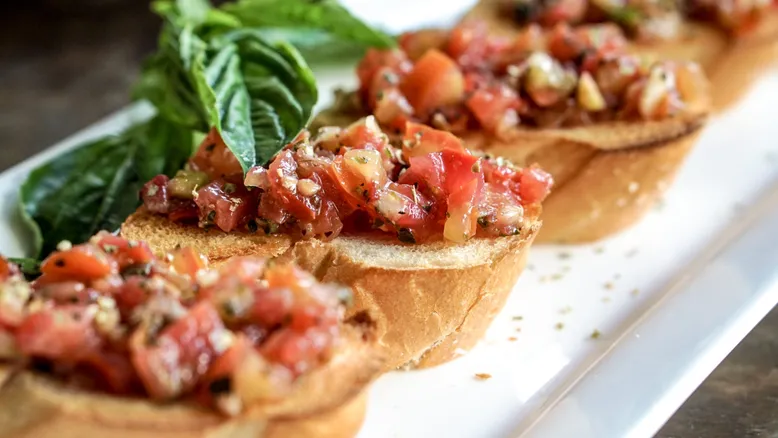Bruschetta croustillante garnie de tomates fraîches, basilic et huile d'olive, apéritif italien classique.