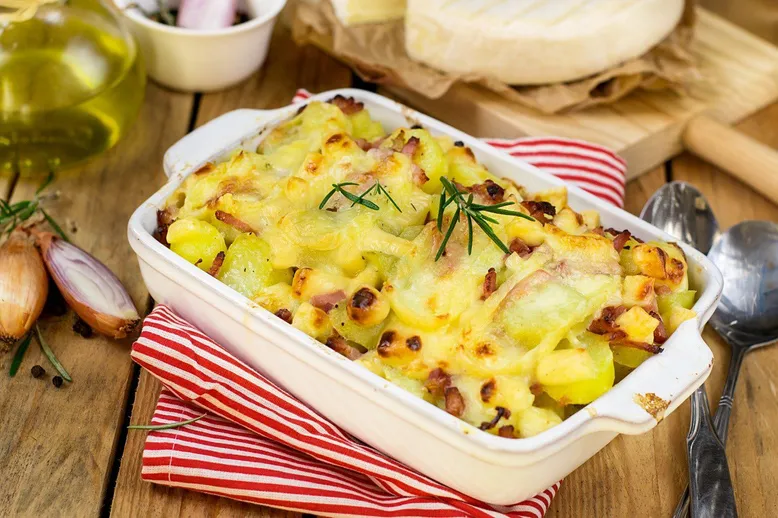Plat à gratin de pommes de terre au lard et fromage gratiné, avec oignons et huile d'olive.