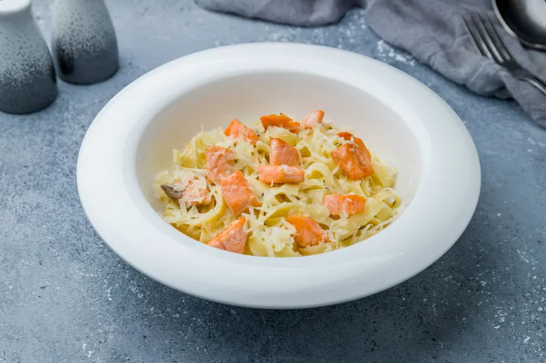 Bol de pâtes (tagliatelles ou fettuccine) au saumon fumé et parmesan râpé.