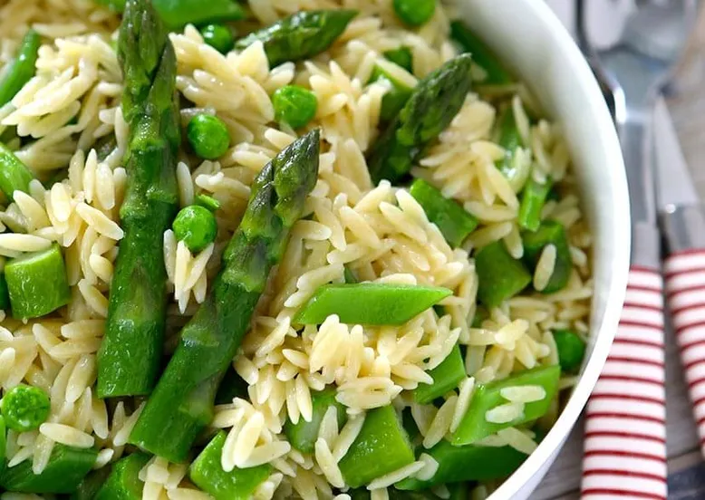 Bol de pâtes orzo aux petits pois et asperges vertes.