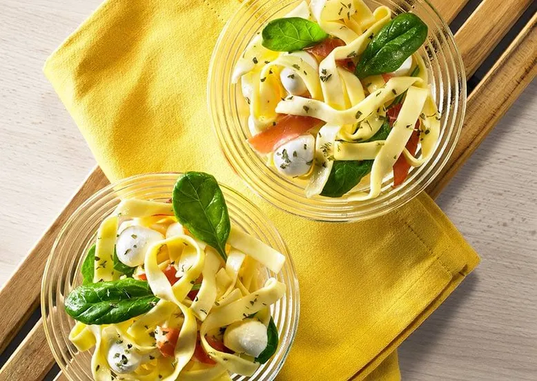 Assiettes de tagliatelles Panzani avec speck épinards et mozzarella, un plat italien savoureux et fumé, facile à réaliser.