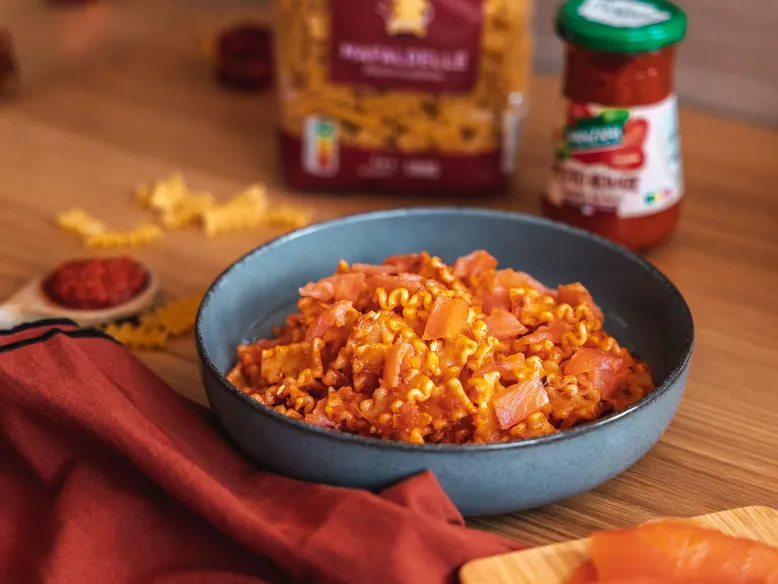 Bol de mafaldine au saumon et sauce tomate, avec sachet de pâtes Panzani en arrière-plan.