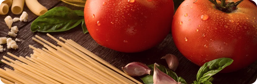 Ingrédients frais pour cuisine italienne : tomates juteuses, ail, basilic, pâtes Panzani et huile d'olive.